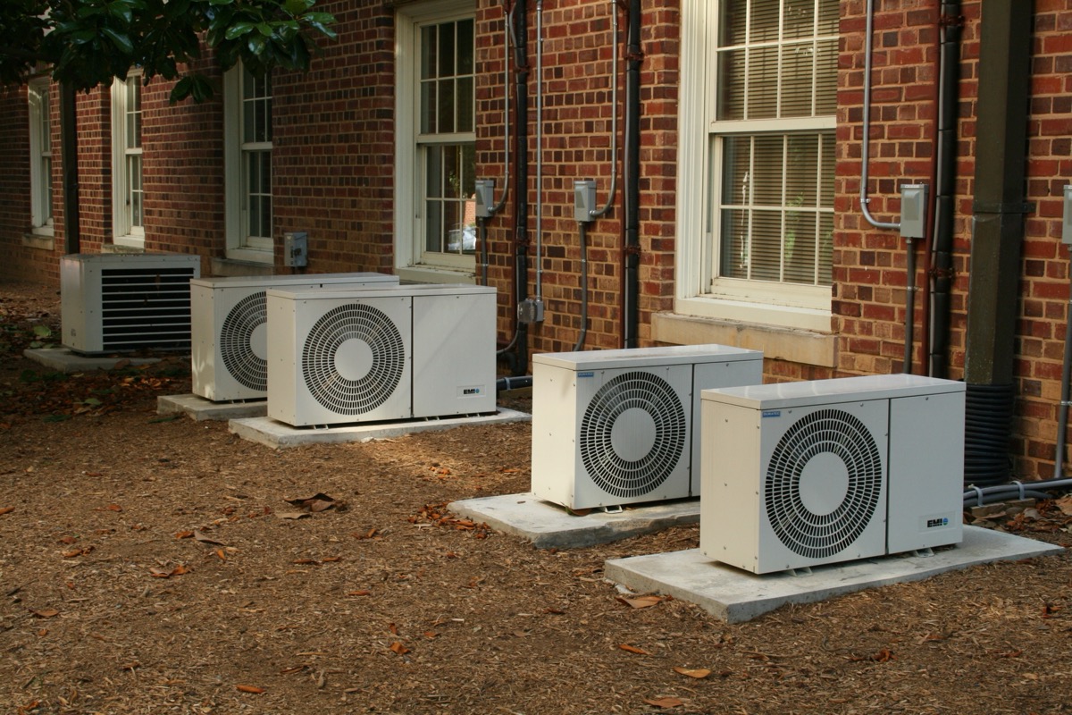 Residential air conditioning outdoor units installed against a building wall